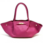 Pink handbag with gold accents on a white background