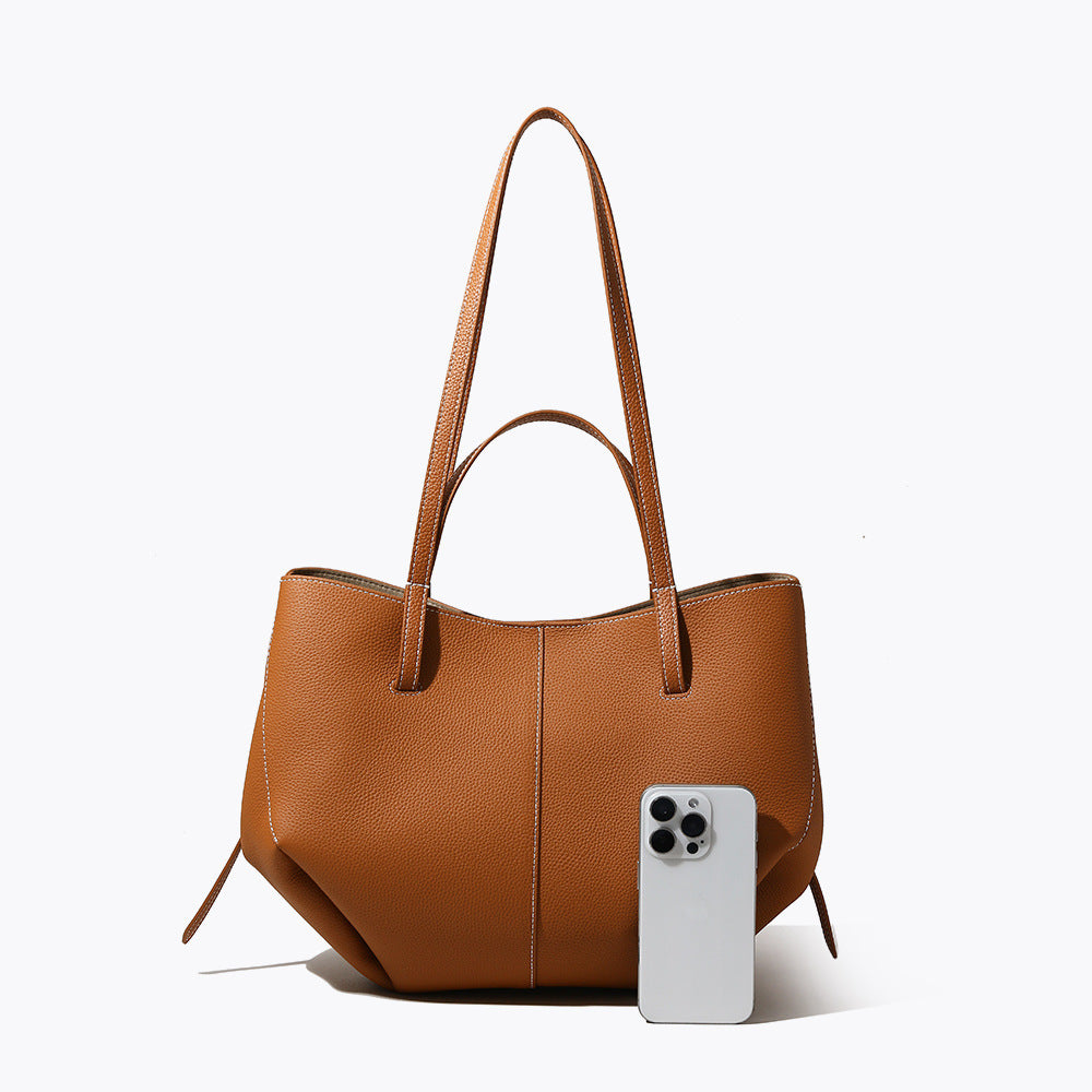 Brown handbag with a smartphone on a white background