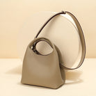 Beige handbag with a circular handle on a beige background