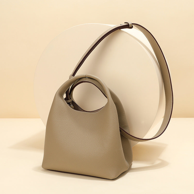 Beige handbag with a circular handle on a beige background