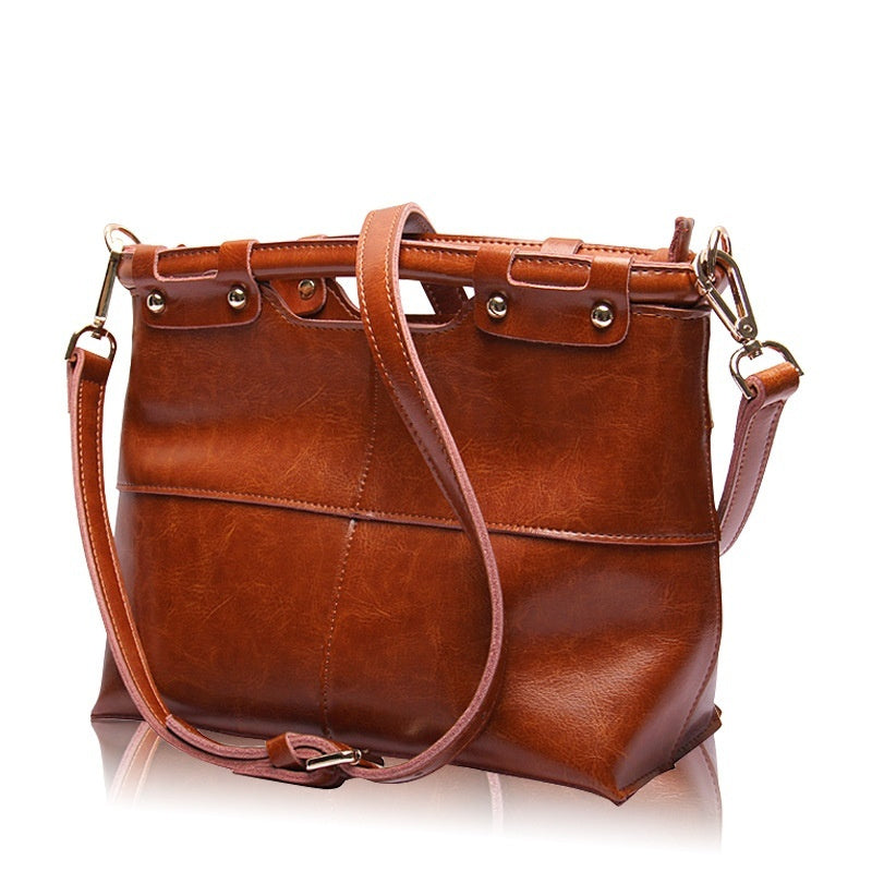 Brown leather handbag with a strap on a white background