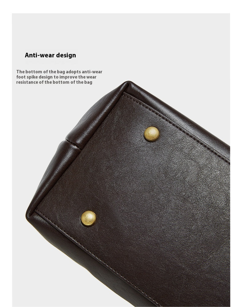 Black leather bag with gold rivets on a white background