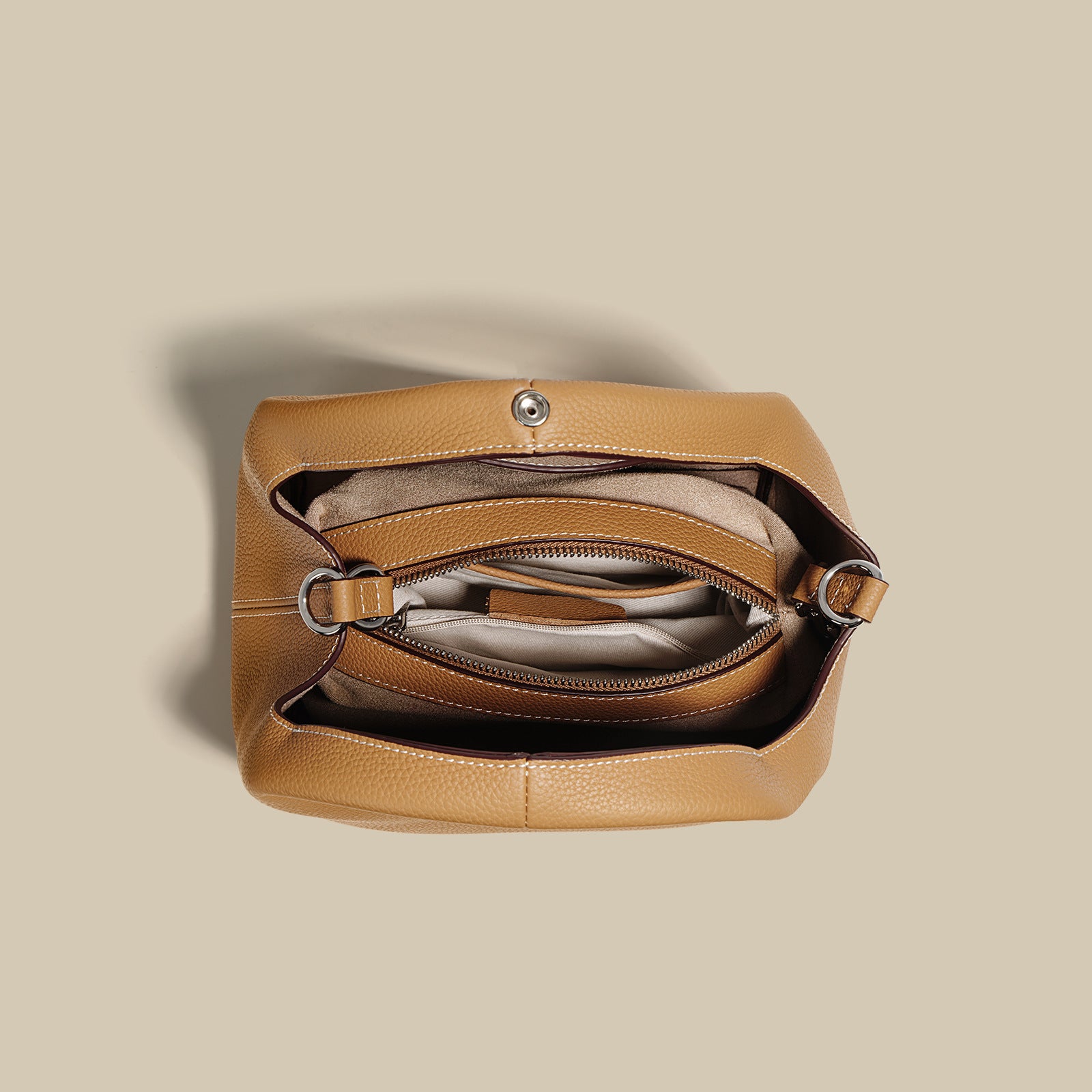 Tan leather handbag on a beige background