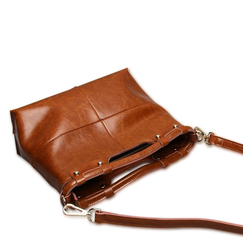 Brown leather handbag with a strap on a white background