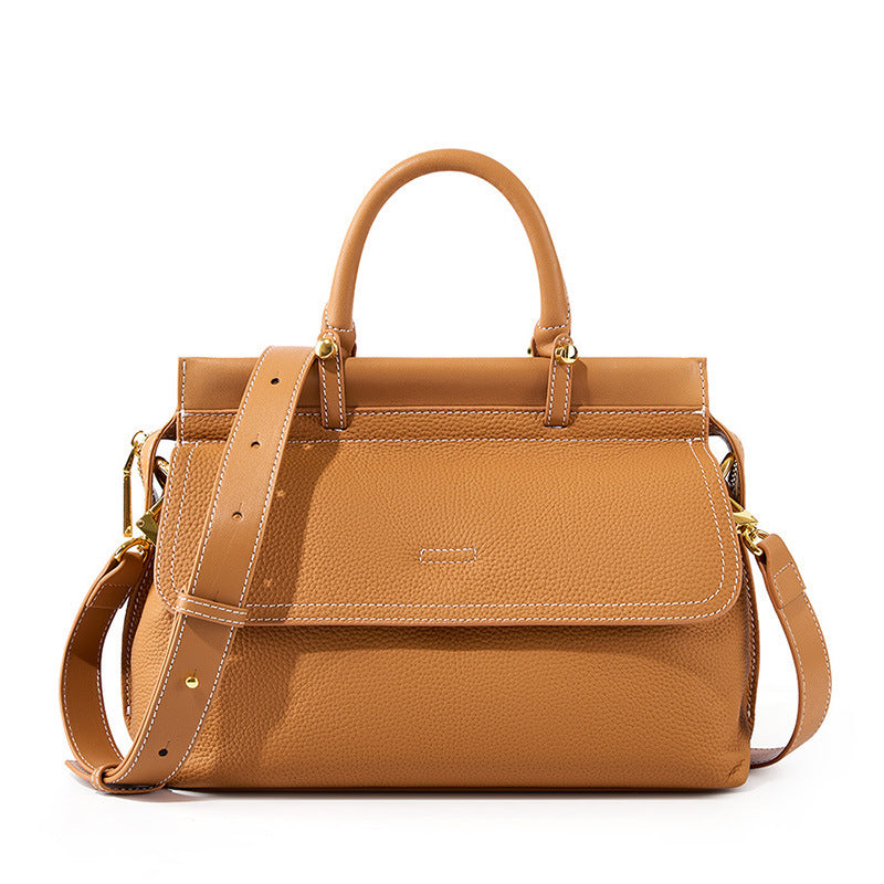 Brown leather handbag with a shoulder strap on a white background