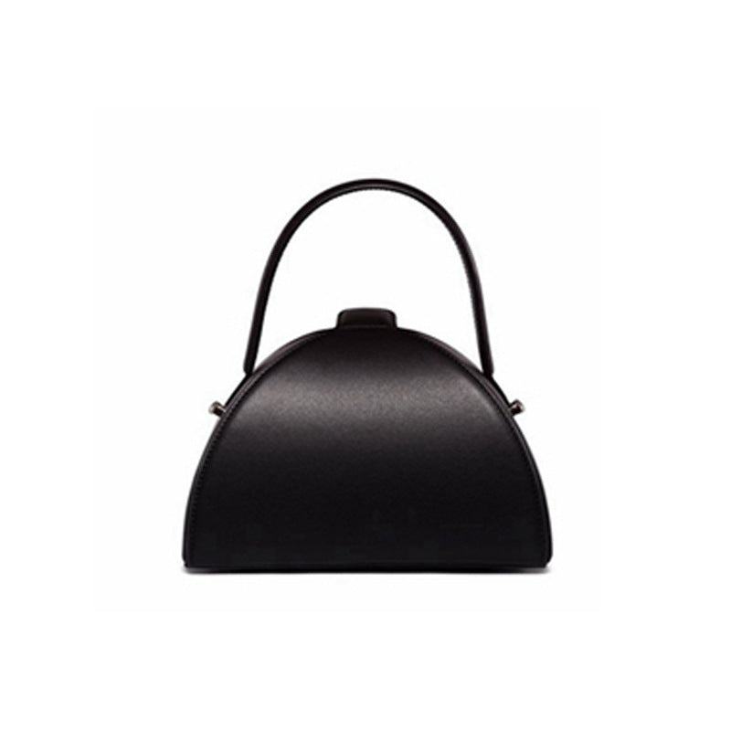 Black handbag with a curved design on a white background