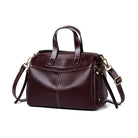 Brown leather handbag with gold hardware on a white background