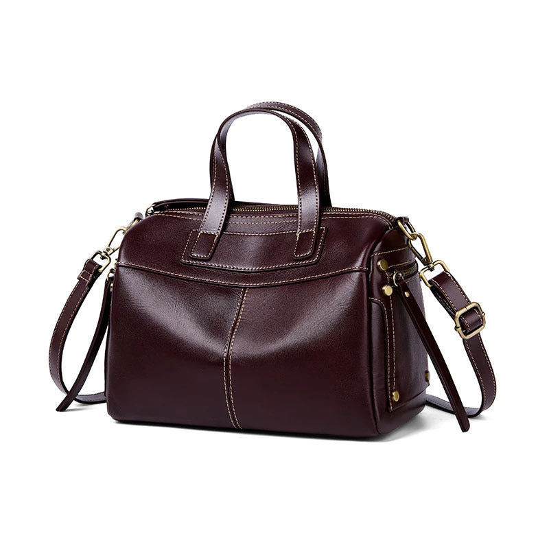 Brown leather handbag with gold hardware on a white background