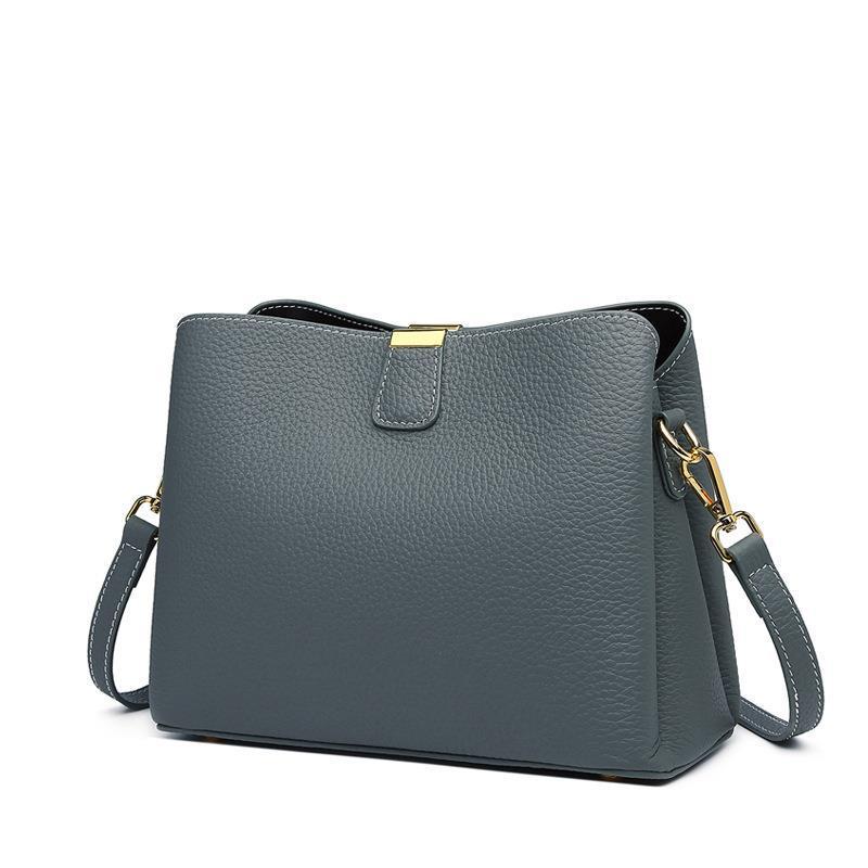 Gray handbag with a gold clasp on a white background